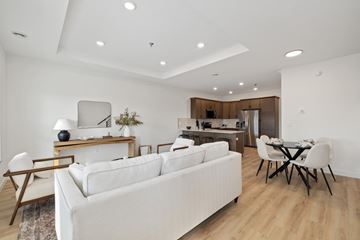 Fargo townhouse for rent - A white couch sits in a modern living room with a dining table and chairs.