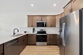 Fargo townhouse for rent - A modern kitchen with wooden cabinets and stainless steel appliances.