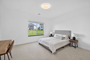Fargo townhouse for rent - A bedroom with a large bed and a wooden table.