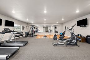 Mandan apartment for rent - A spacious home gym with a variety of exercise equipment.