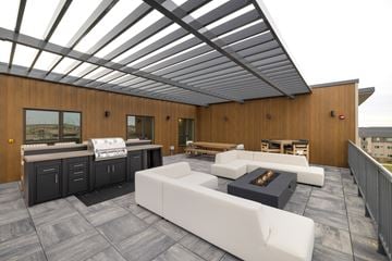 Fargo apartment for rent - A modern outdoor living space with a white couch and a fireplace.