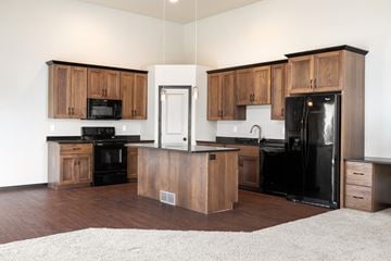 Fargo townhouse for rent - A kitchen with wooden cabinets and black appliances.