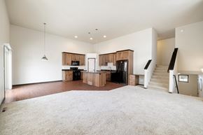 Fargo townhouse for rent - A spacious living room with a staircase leading to the upper floor.