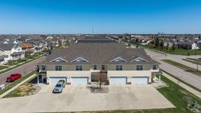 Fargo townhouse for rent - A large house with a grey roof and a red car in front.