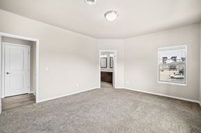 Fargo townhouse for rent - A spacious room with a door, a window, and a carpeted floor.