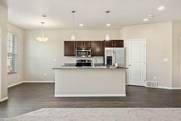 West Fargo townhouse for rent - A kitchen with a white counter and brown cabinets.