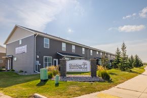 West Fargo townhouse for rent - A building with a sign that says Shadow Creek Wood.
