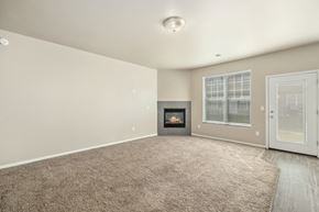 West Fargo townhouse for rent - A spacious living room with a fireplace and a carpeted floor.