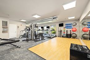 Fargo apartment for rent - A gym with a variety of equipment including a treadmill, weights, and a bench press.