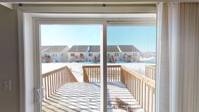 West Fargo townhouse for rent - A view from inside a room looking out to a snowy deck and houses.