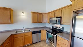 West Fargo townhouse for rent - A kitchen with wooden cabinets and stainless steel appliances.