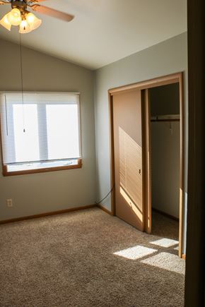 West Fargo triplex for rent - A room with a ceiling fan and a window with blinds.