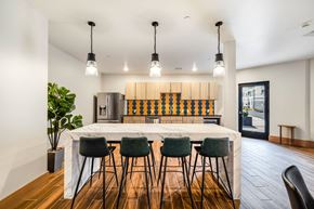 West Fargo apartment for rent - a kitchen with a large island and bar chairs at Northern Lights a Lifestyle-Driven Community, North Dakota