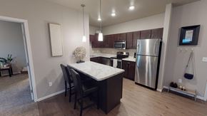 Moorhead apartment for rent - A kitchen with a table and chairs in front of a refrigerator.