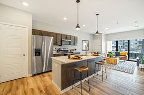 Fargo apartment for rent - a kitchen with a large island and a stainless steel refrigerator at EagleRidge Plaza Residences, Fargo, ND, 58104