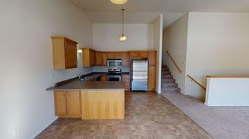 West Fargo townhouse for rent - A kitchen with wooden cabinets and a tiled floor.