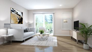 Fargo apartment for rent - A living room with a white couch, a painting on the wall, and a potted plant.