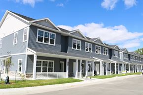 Fargo townhouse for rent - A row of houses with grey siding and white trim.
