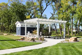 Fargo townhouse for rent - A white gazebo is surrounded by a grassy area and trees.