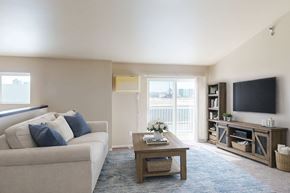 West Fargo apartment for rent - A living room with a couch, a coffee table, and a television.
