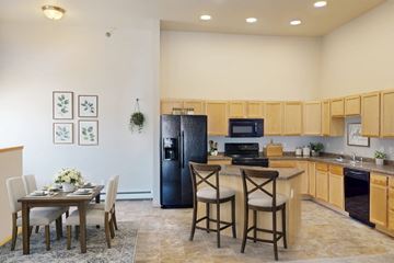 West Fargo apartment for rent - A kitchen with a table and chairs in the middle of the room.