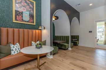Temple apartment for rent - A living room with a round table and a couch with a green cushion.