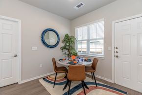 Waco apartment for rent - A dining room with a round mirror and a table with chairs.
