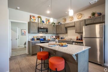 Tyler apartment for rent - A kitchen with a refrigerator, microwave, and stove top oven.