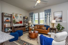 Tyler apartment for rent - A living room with a brown sofa, a white armchair, and a coffee table.