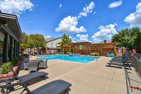 Wichita Falls apartment for rent - a swimming pool with lounge chairs and a fence around it