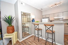 Wichita Falls apartment for rent - a bar area with stools and a mirror in a living room