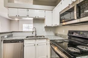 Irving apartment for rent - a kitchen with white cabinets and black appliances at Foxborough Apartments, Irving, TX, 75061