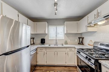 Laughlin apartment for rent - an updated kitchen with white cabinets and stainless steel appliances