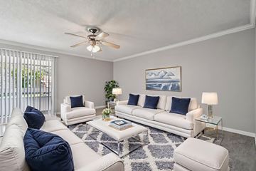 Phoenix apartment for rent - A living room with a white couch, a blue chair, and a painting on the wall.