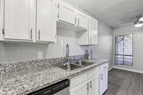 Las Vegas apartment for rent - A kitchen with granite countertops and white cabinets.