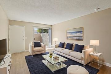 Las Vegas apartment for rent - A living room with a white couch, a glass coffee table, and a painting on the wall.