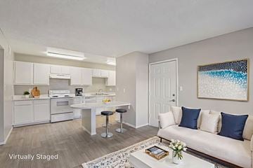 Las Vegas apartment for rent - A virtually staged living room with a white couch and a painting on the wall.