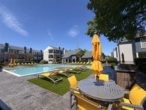 Garland apartment for rent - A pool area with yellow chairs and umbrellas.