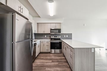 Kent apartment for rent - A modern kitchen with a stainless steel refrigerator and wooden flooring.