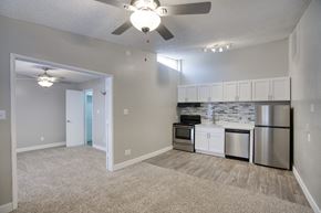 Phoenix apartment for rent - a living room with a ceiling fan and a kitchen with stainless steel appliances at Valencia Park, Phoenix, Arizona, 85008