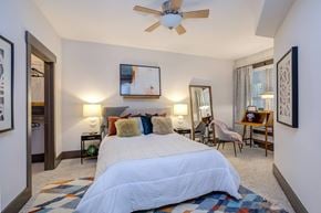 Raleigh apartment for rent - A bedroom with a large bed and a ceiling fan.
