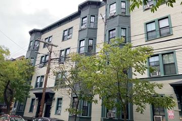Cambridge apartment for rent - A multi-story building with a mix of green and beige siding.