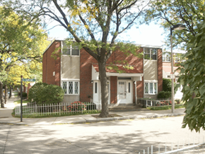Roxbury townhouse for rent - A red brick house with a white fence in front.
