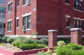 Dorchester apartment for rent - A red brick building with a white window and a small white pillar in front of it.