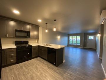 River Falls townhouse for rent - A kitchen with dark wood cabinets and a black stove top oven.