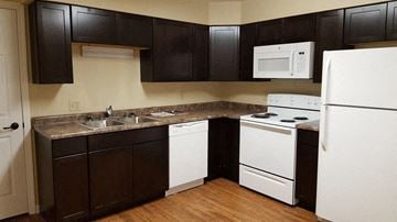 La Crosse apartment for rent - A kitchen with white appliances and brown cabinets.