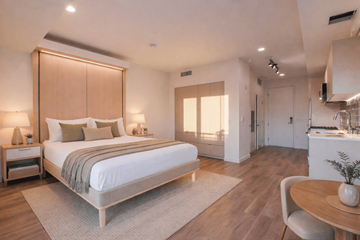 La Crosse apartment for rent - A bedroom with a large bed and a dining area in the background.