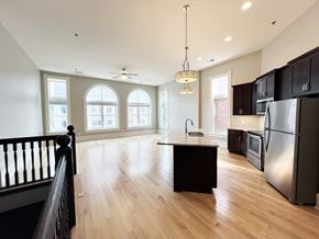 La Crosse apartment for rent - an open kitchen and living room with wood floors and black cabinets