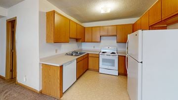 La Crosse apartment for rent - a kitchen with white appliances and wooden cabinets
