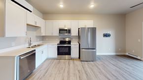New Richmond apartment for rent - A kitchen with white cabinets and a wooden floor.